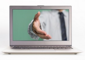 Business man hand reaching out from screen to shake with white  background