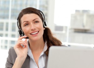 Thoughtful businesswoman talking on the phone while working on her computer at the office