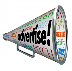 A bullhorn megaphone covered with words describing advertising such as advertise, promotion, public relations, marketing, attention, audience, plug, buzz and many more