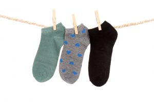 three socks hanging on a rope clothesline isolated on white